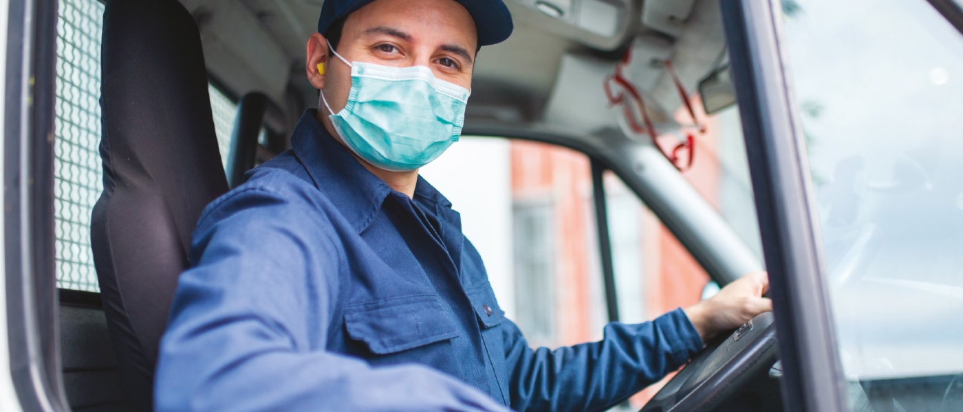 Plombier portant un masque dans son camion.