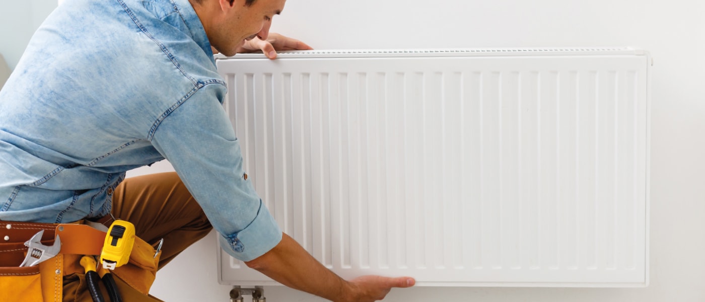 Plombier installant un radiateur.