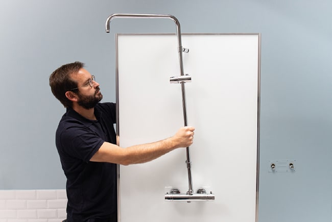 Artisans en train d’installer la barre de douche.