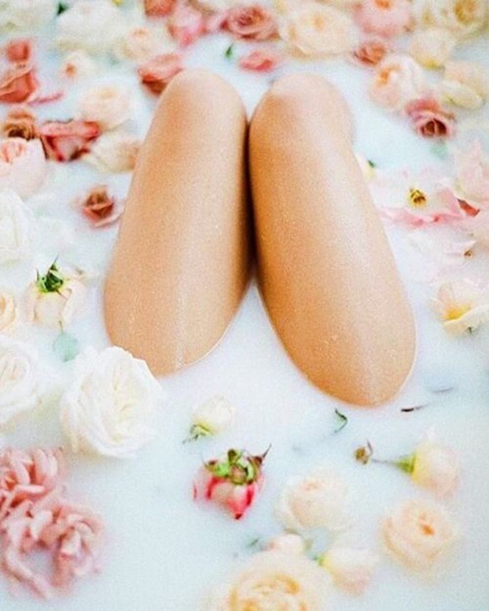 Photo genoux de femme qui sortent d’un bain au lait de fleurs